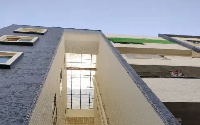 Netting covering the tall open duct between sections of a residential building