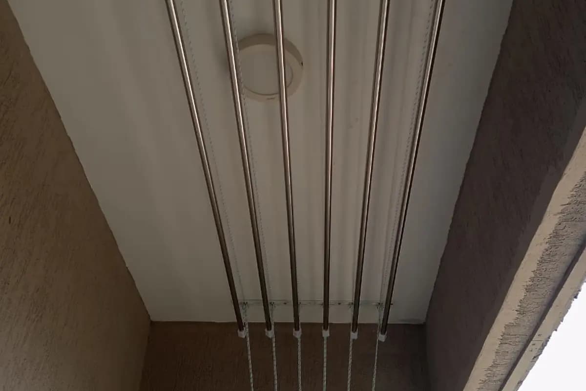Parallel drying rods and cords mounted below a balcony ceiling